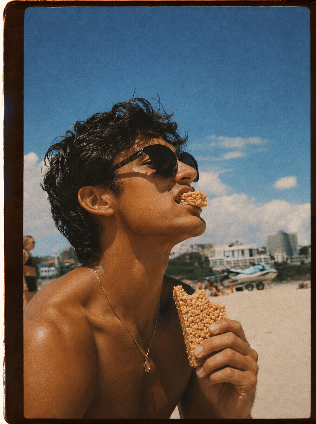 A big kid in the sun biting into a crispy rice treat