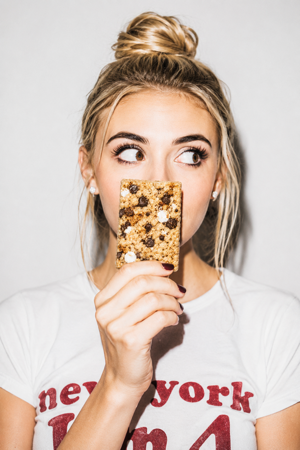 A big kid biting into a crispy rice treat in the studio
